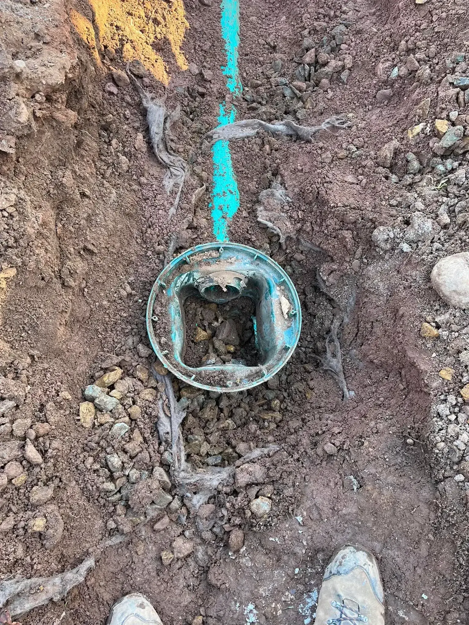 An excavated septic distribution box exposed in an open trench during a Summit Septic repair