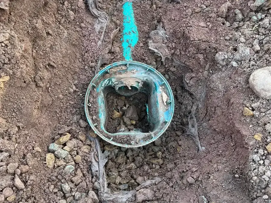 A septic distribution box exposed in an open trench during a Summit Septic repair